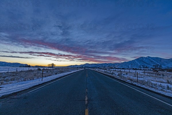 Pink dawn over rural highway and mountains