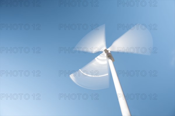 Low angle view of wind turbine against blue sky