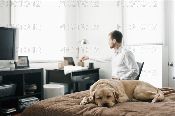 Caucasian businessman working in bedroom