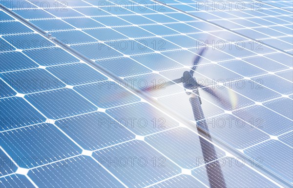 Wind turbine reflected in solar panels