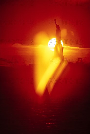 Silhouette of Statue of Liberty at sunset