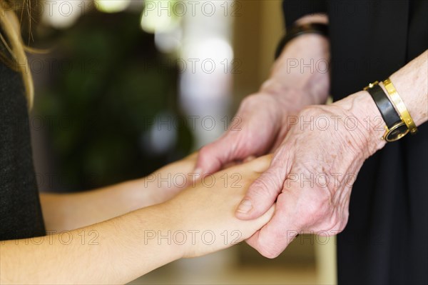 Close-up of grandmother and granddaughter (8-9) holding hands