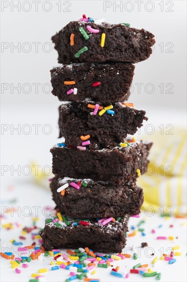 Stack of freshly baked brownies covered with colorful sprinkles