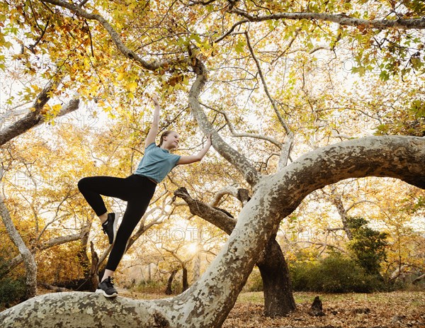 Girl exercising on tree branch