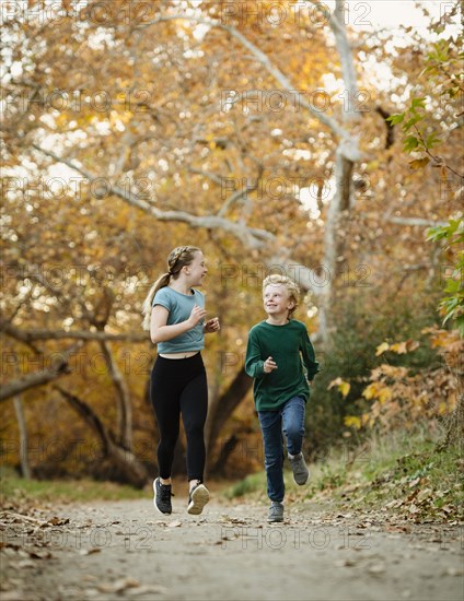 Boy and girl running on footpath in forest