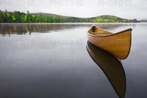 Wooden canoe floating on calm Upper Saranac Lake
