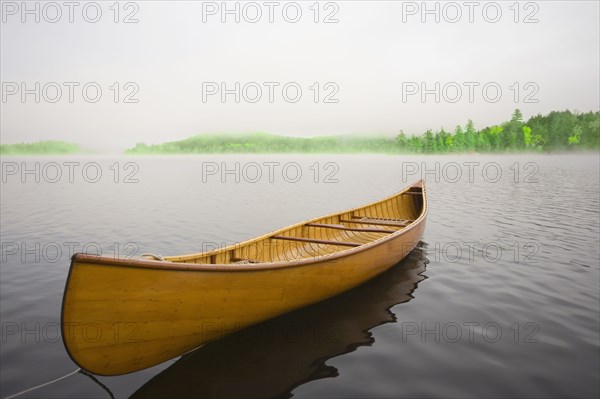 Wooden canoe floating on calm Upper Saranac Lake