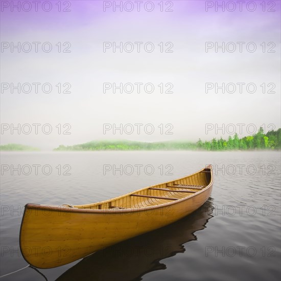 Wooden canoe floating on calm Upper Saranac Lake