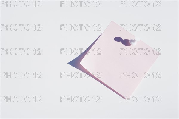 Studio shot of blank pink adhesive post it note