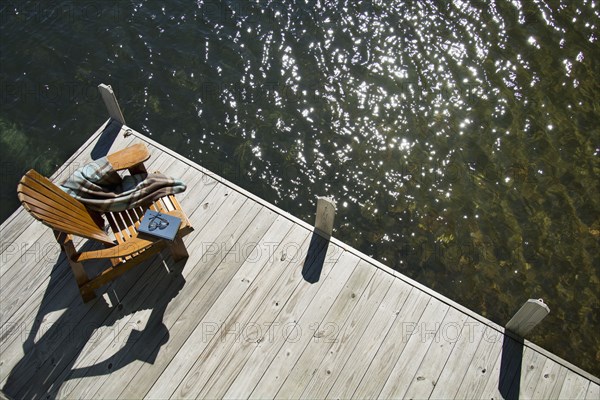 Overhead view of Adirondack chair book and blanket on wooden pier