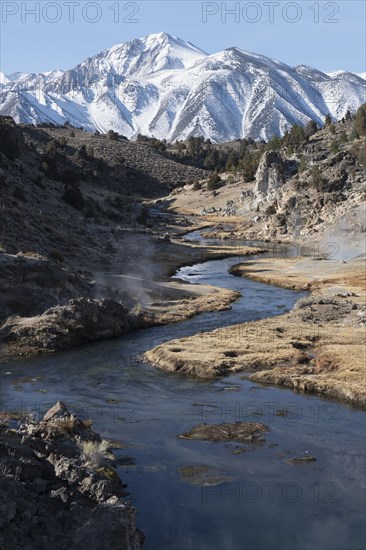 Creek with hot springs with snow covered mountain in background