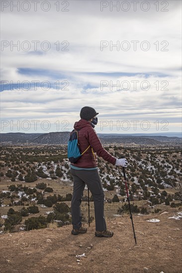 Senior woman wearing face mask hiking in Galisteo Basin Preserve