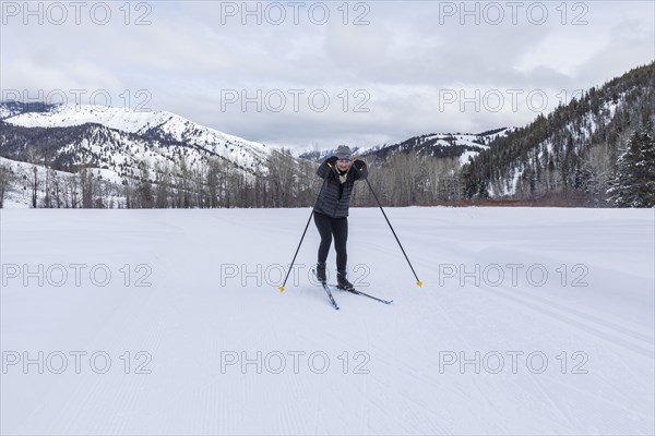 Senior woman cross - country skiing on groomed trails