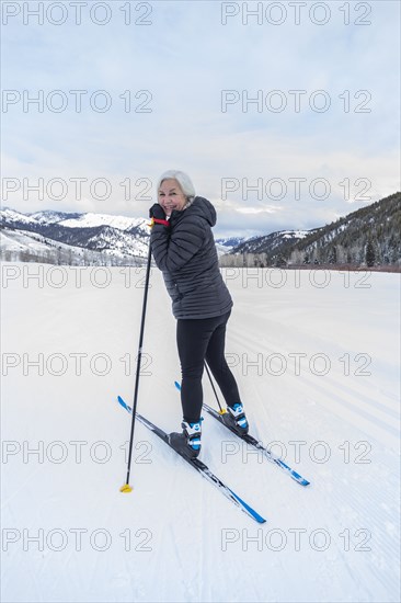 Senior woman cross - country skiing on groomed trails