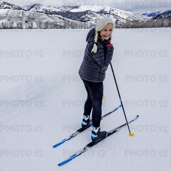 Portrait of senior woman cross - country skiing on groomed trails