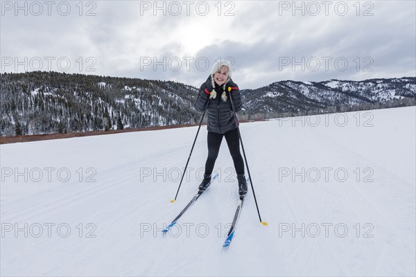 Portrait of senior woman cross - country skiing on groomed trails