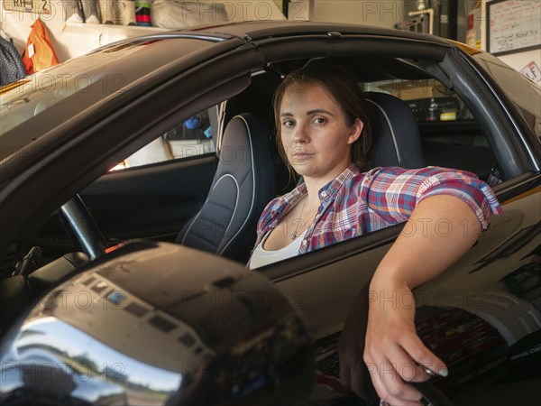 Woman sitting in car in garage