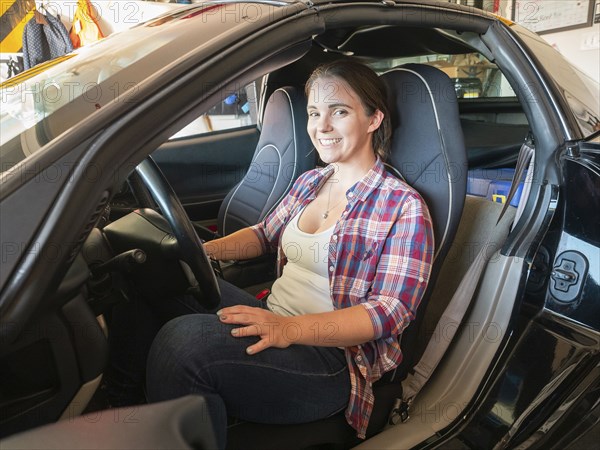 Woman sitting in car in garage