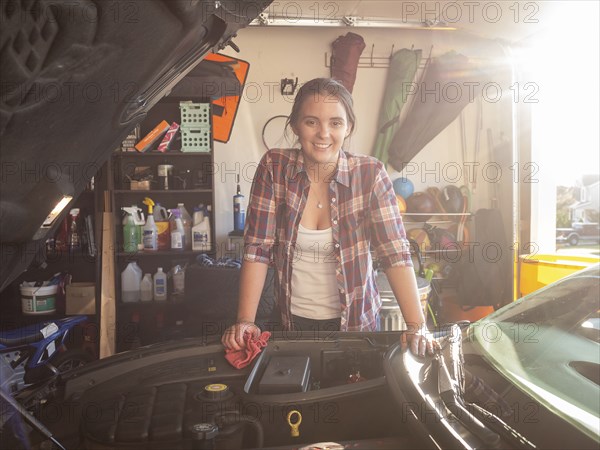 Woman fixing car in garage