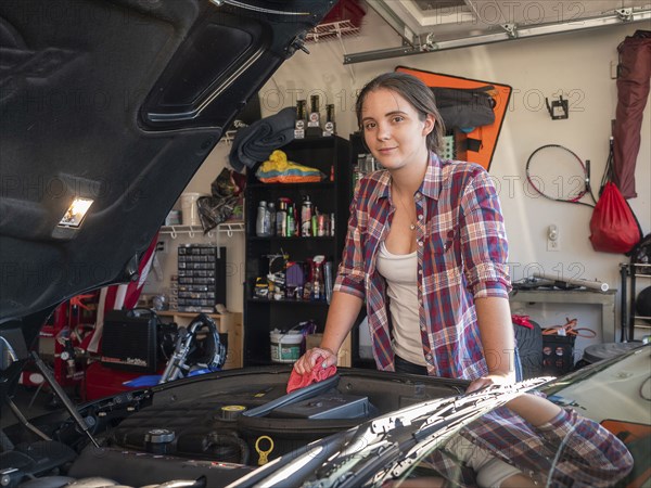 Woman fixing car in garage