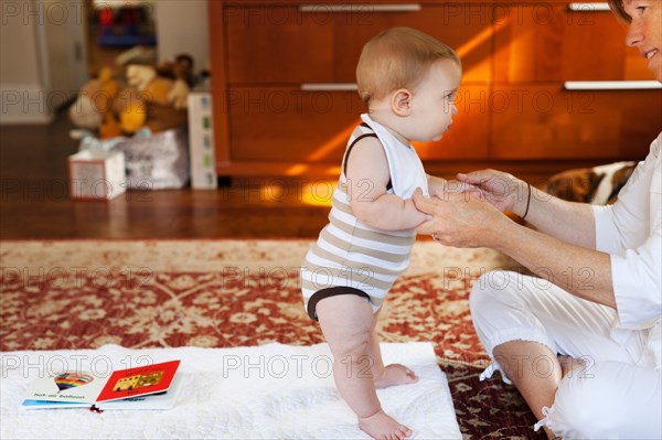 Mother and baby son playing on carpet