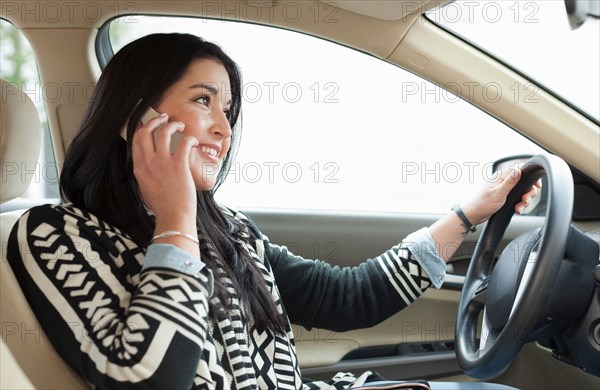 Young woman on cell phone driving car
