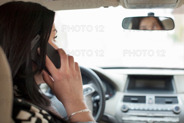 Young woman on cell phone in car