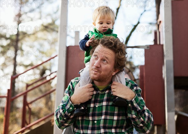 Father carrying son on shoulders in park