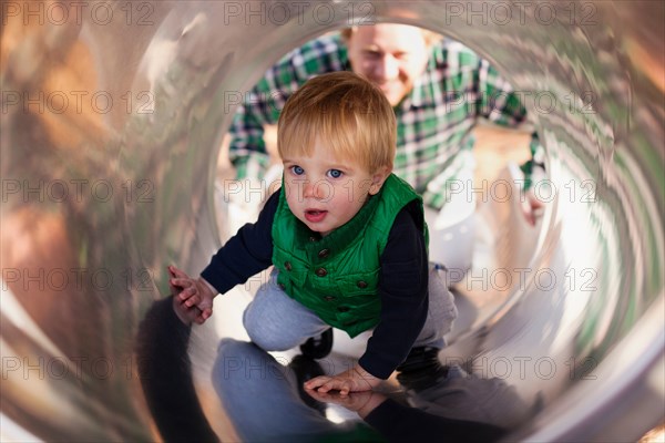 Boy climbing up slide in playground