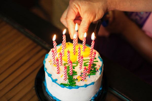 Hand putting candles into cake