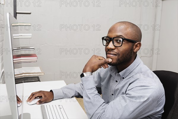 Portrait of young man using computer in design office