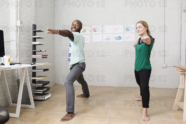 Young business partners doing exercises in design office