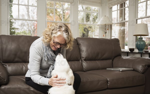 Senior woman with labrador dog in living room