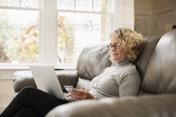 Senior woman shopping online on laptop