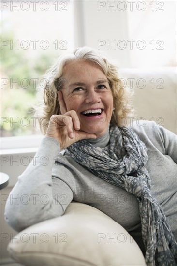 Relaxed senior woman sitting on sofa