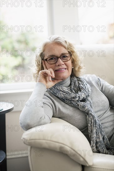 Portrait of happy senior woman sitting on sofa