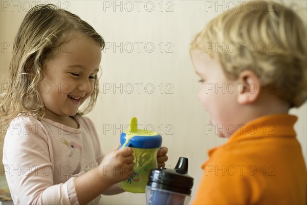 Male and female toddler friends having a drink