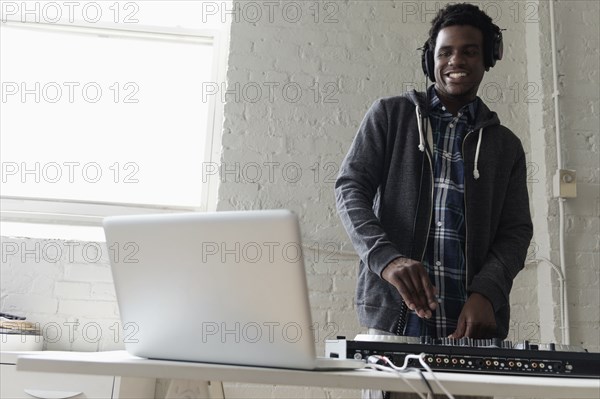 DJ using laptop and mixing desk