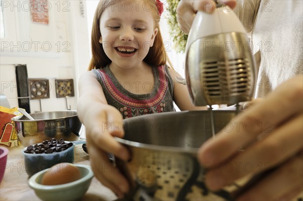 Girl giving mother a helping hand in kitchen