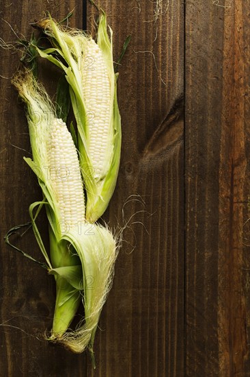 Overhead view of two corn cobs on table