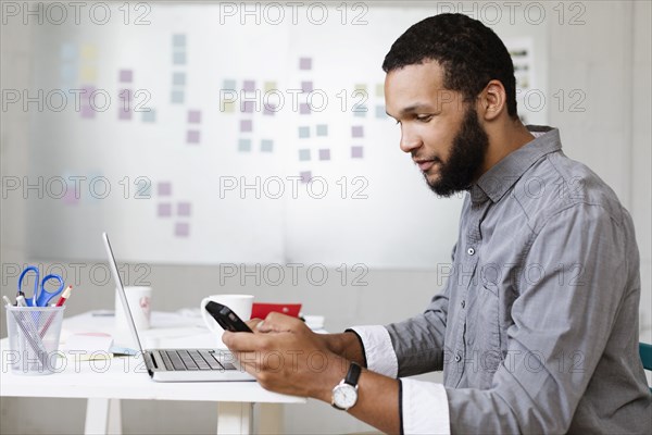 Man using smartphone in Small Business