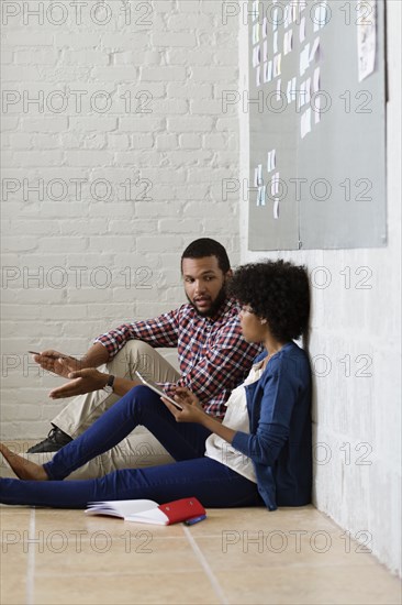 Colleagues sitting on floor and having discussion Small Business