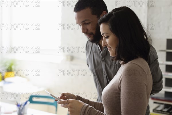 Colleagues looking at digital tablet Small Business