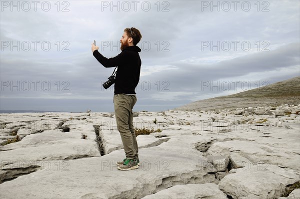 Mid adult man taking photo on phone