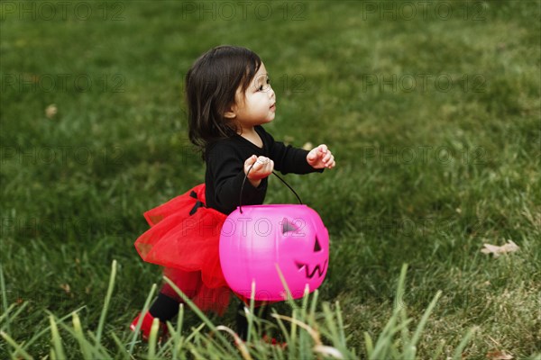 Girl in fancy dress costume with trick or treat bucket