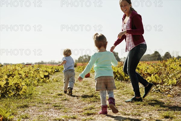 Mother with two children in pumpkin field