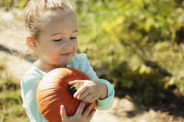 Girl carrying pumpkin