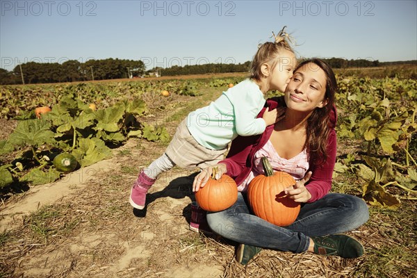 Mother and daughter in pumpkin field