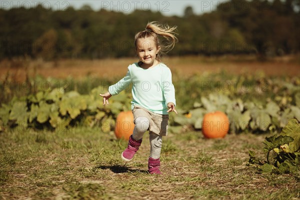 Girl running in pumpkin field