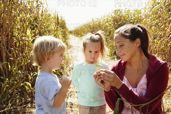 Mother with two children in field with crops